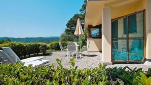 A modern outdoor patio with a pool, lounge chairs, and a glass-enclosed room. - Rustic Escape in Palazzuolo Stay (Palazzuolo sul Senio)