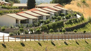 A row of modern villas with sloped roofs, surrounded by lush greenery and vineyards, set against a backdrop of mountains. - Rustic Escape in Palazzuolo Stay (Palazzuolo sul Senio)