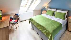 A bedroom with a bed, a desk, and a chair. There are skylights above the bed. - Apartment in Darlowko Near Beach & Water Park (Darlowo)