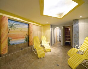 A sunlit room with a mural of a sunset, a marble column, and yellow-striped lounge chairs. - Apartment in Milders Near Stubai Glacier (Neustift Im Stubaital)