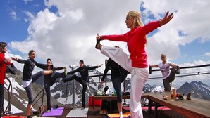 A group of people performing yoga on a wooden deck with a mountain backdrop. - Apartment in Milders Near Stubai Glacier (Neustift Im Stubaital)