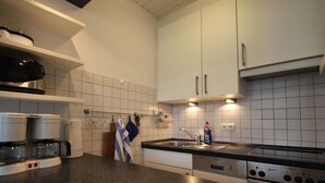 A modern kitchen with white cabinets, a granite countertop, a Siemens stove, and a coffee maker. - Doppelhaushhlfte in Burhave (Butjadingen)