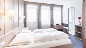 Une chambre d’hôtel avec un grand lit, un bureau, une chaise et une petite table.