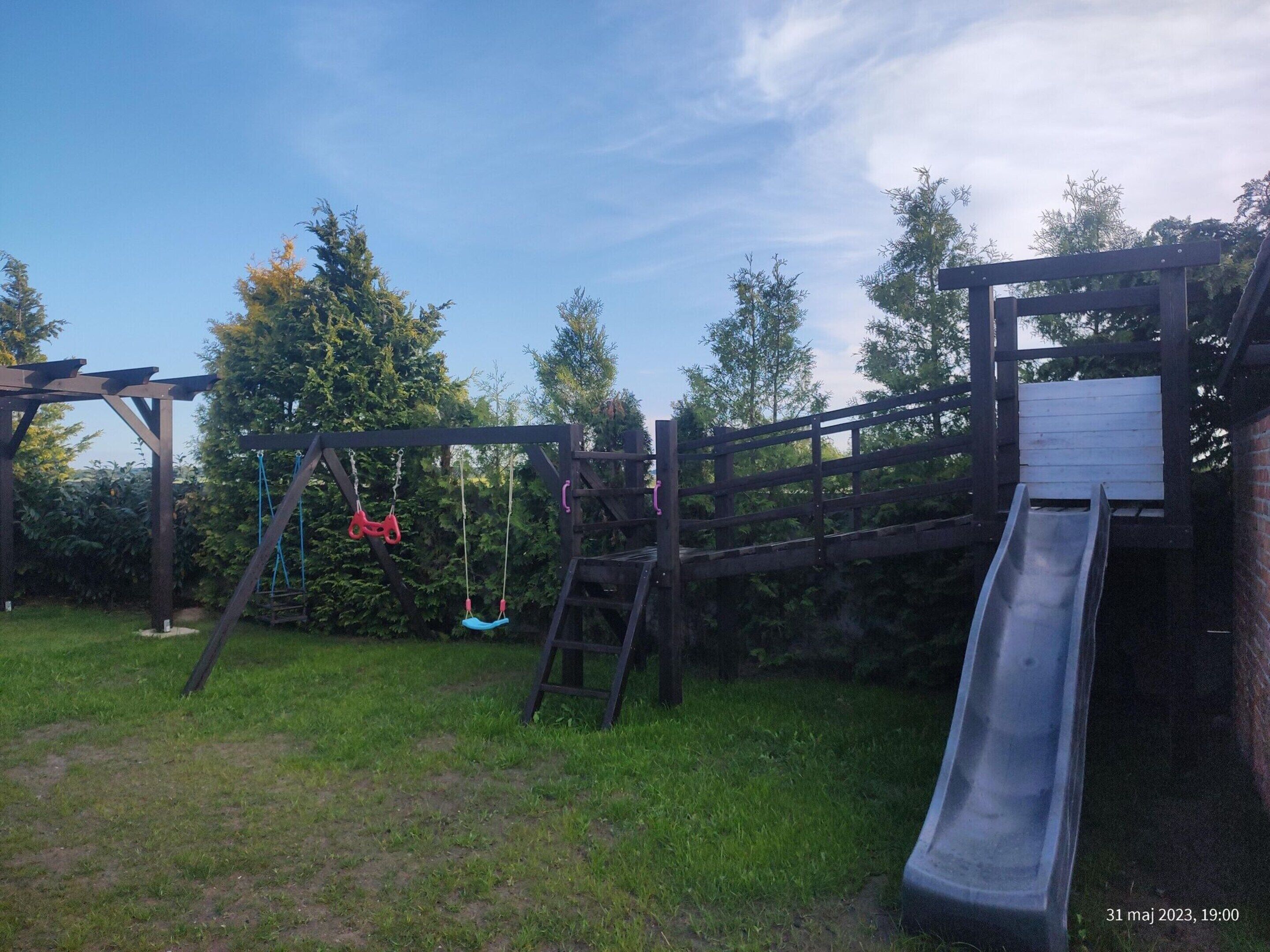 A playground with a slide and swings.