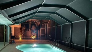 Ein Innenpool mit gewölbter Kante, umgeben von Wänden und einer Decke mit geometrischen Mustern.