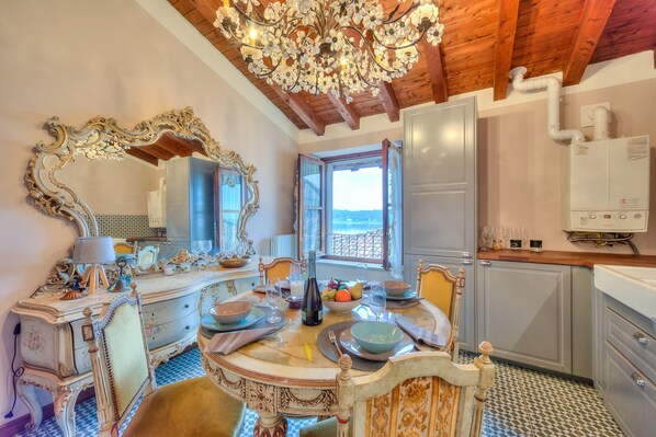 Un espace repas agrémenté de meubles décoratifs, d’un lustre et offrant une vue sur l’extérieur.
