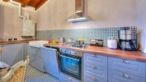 A kitchen with a built-in oven, a stove, and a coffee maker. - Laetitia Historic Center Fantastic View L (Salò)