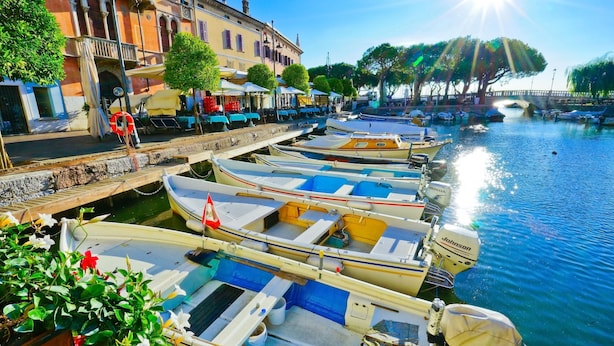 A row of small boats docked along a canal, with buildings and trees in the background. - Mirabelle in Dro With 3 Bedrooms and 2 Bathrooms (Dro)