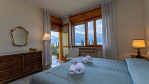 Habitaci ón de hotel con una cama grande, un aparador de madera, un espejo y vistas a montañas desde la ventana.