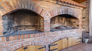 Een bakoven met twee haarden, houten kasten eronder en een betegelde vloer.