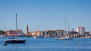 Eine Marina mit vertäuten Booten, einem Turm und Gebäuden mit roten Dächern.
