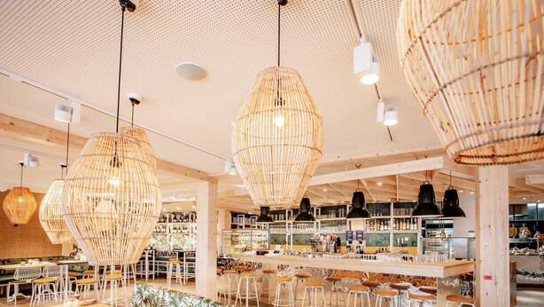 A modern bar area with high wooden ceilings, hanging wicker chandeliers, and a bar counter with stools. - Appartements im Maremuritz Yachthafen Resort (Waren (Müritz))