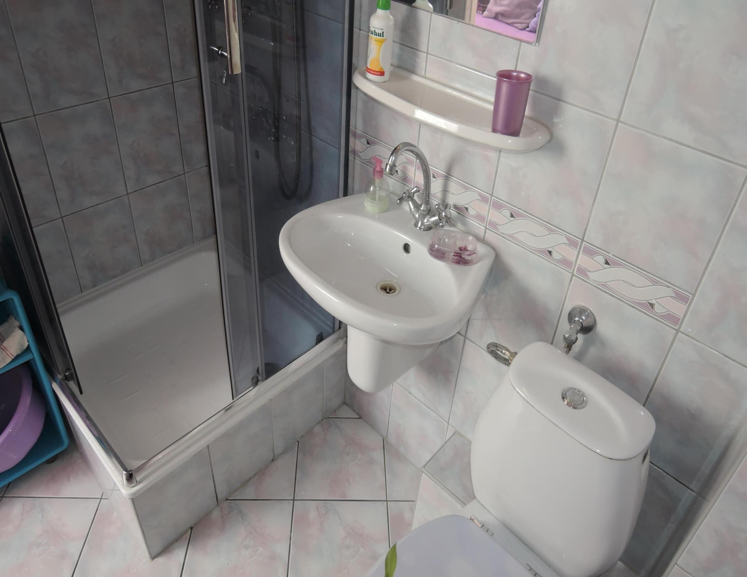 A bathroom with a shower, sink, and toilet.