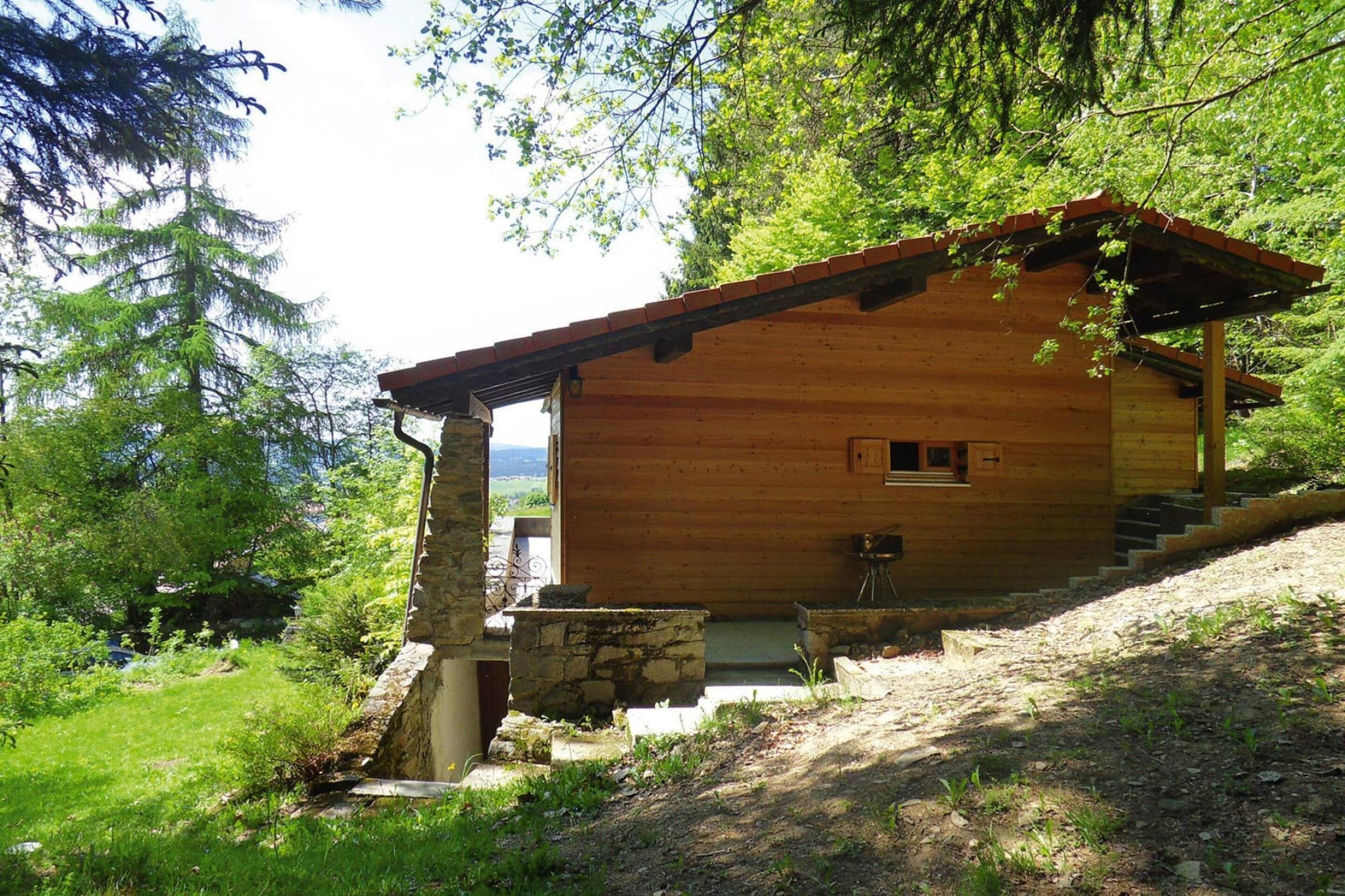 A wooden cabin with a stone foundation, a porch, and a small set of stairs leading to the entrance.