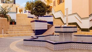 A courtyard with a fountain, tiled steps, and a tree. - Apartment in Pueblo Salado, Mazarron (Mazarrón)