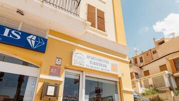 Un edificio amarillo con un cartel que dice 'Pueblo Salado Apartments' y una tienda AT&T a la vista.