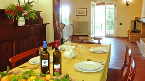 Une table à manger dressée avec des assiettes, des verres et des bouteilles, entourée de chaises.