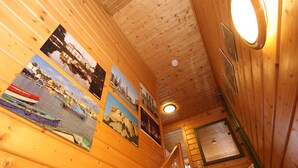 A wooden cabin interior with a staircase, wooden walls, and a ceiling with a circular light fixture. - Doppelhaushalfte in Hasselfelde (Oberharz am Brocken)