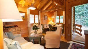 A cozy log cabin interior with a sofa, chairs, a dining table, and a view of the outdoors. - Blockhauser in Stamsried (Stamsried)