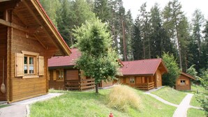 Une rangée de cabanes en rondins, avec une borne d’incendie au premier plan.