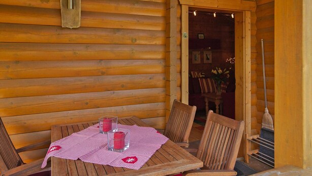 A wooden cabin with a table set for two, featuring a checkered tablecloth and two candles. - Blockhauser in Stamsried (Stamsried)