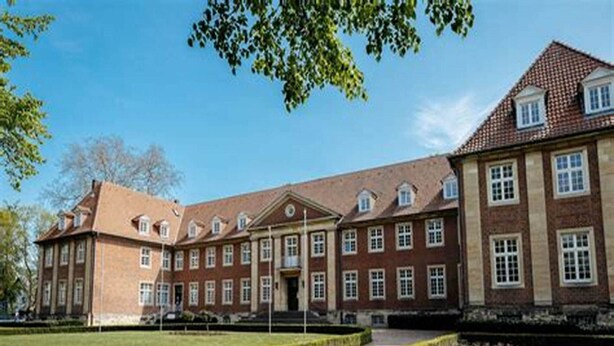 A large, historic building with symmetrical architecture, multiple windows, and a well-maintained lawn. - Liebevoll Eingerichtete Ferienwohnung in Husum (Husum)