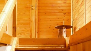 A wooden interior with a staircase, a wall-mounted light fixture, and a framed picture. - Holiday Home in Kashubia Near Lake (Suleczyno)