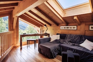 Uma cabana de madeira acolhedora com um quarto no mezanino, uma varanda com vista e uma área de jantar.