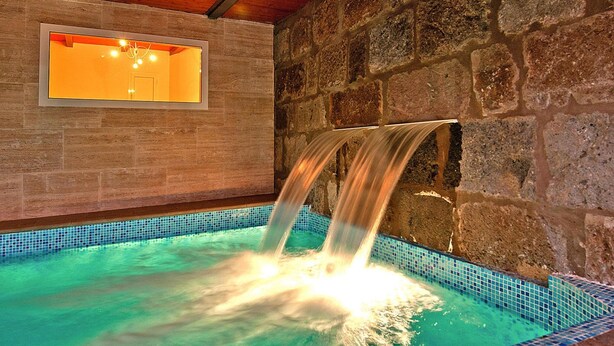 A spa area with a stone wall, a wooden ceiling, and a small window. - Villa With Pool and Beautiful Architecture (Ingenio)