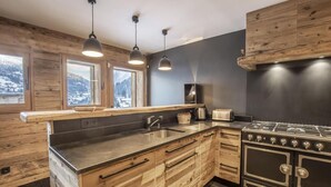 A modern kitchen with wooden cabinetry, a stainless steel sink, and a gas stove.
