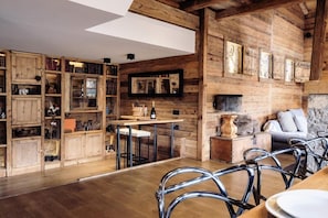 Ein rustikales Interieur mit Holzwänden, einem Kamin, einer Bar und einer gemütlichen Sitzecke.
