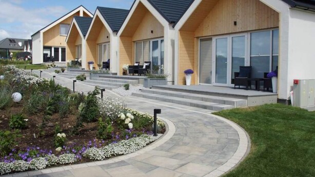 A row of modern, wooden-roofed cottages with large windows and outdoor seating areas. - Air-conditioned Holiday Homes, 2 Bedrooms (Mielno)
