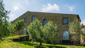 A stone building with a garden, a patio with chairs, and a stone pathway. - Apartment in Montaione With Fireplace (Montaione)