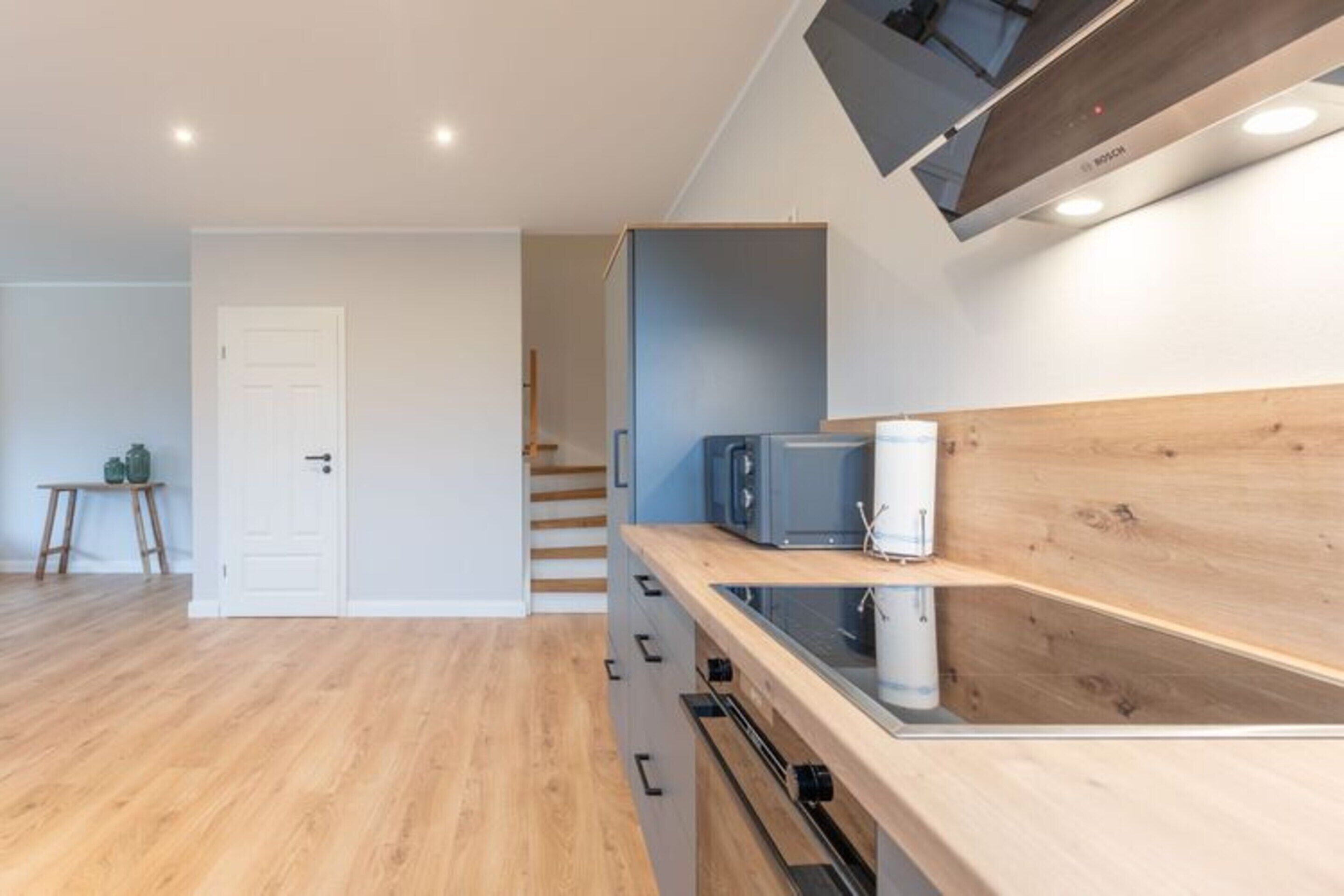 Een moderne keuken met houten kastjes, een magnetron en een inbouwoven.