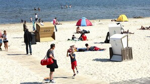 A beach with people sunbathing, a wooden deck, and a tent. - Haustierfreundliches Ferienhaus in Peenemunde (Peenemünde)