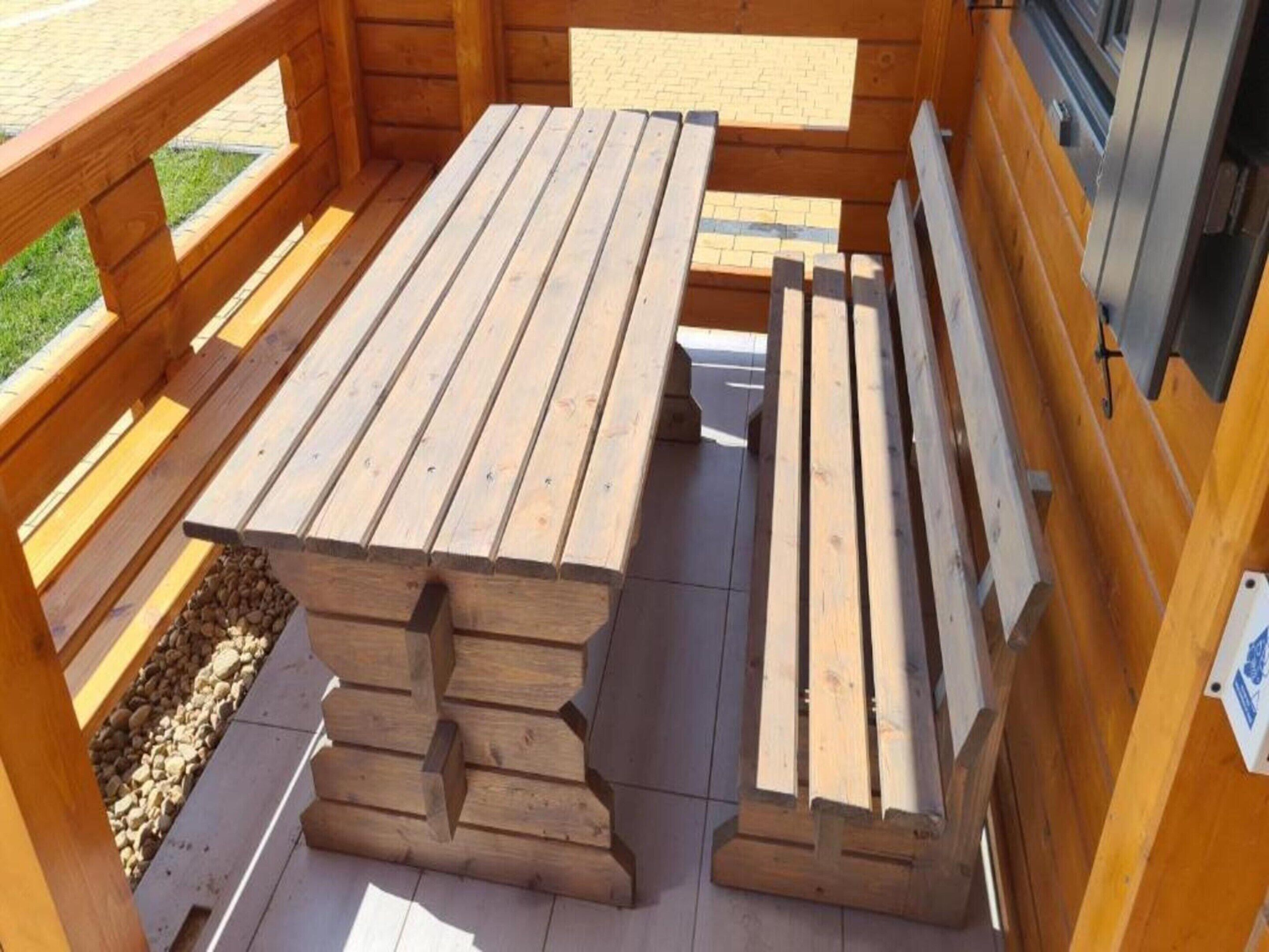 A wooden deck with a picnic table and benches.