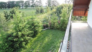 Un balcón con vistas a un área verde y árboles.