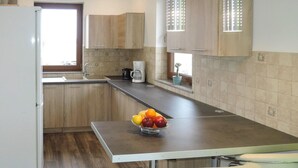 Una cocina moderna con armarios de madera, encimera de acero inoxidable y un tazón de fruta.