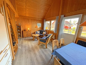 A wooden cabin interior with a sofa set, a dining table, and a bed. - Holiday House at the Useriner See, Userin (Userin)