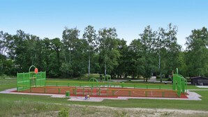 A playground with various equipment including a basketball hoop, climbing structures, and a running track. - Holiday House at the Useriner See, Userin (Userin)