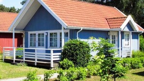 A blue and white two-story house with a red-tiled roof, surrounded by greenery. - Holiday House at the Useriner See, Userin (Userin)