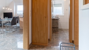 A modern kitchen with wooden cabinets, a marble countertop, and a window with blinds. - Wohnung in St. Peter Ording (St. Peter-Ording)