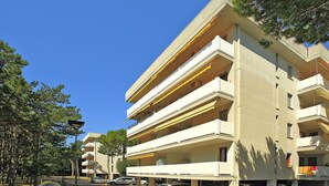 Un edificio residenziale a più piani con balconi, un'area di parcheggio e un lampione di strada.