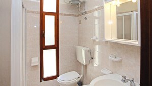 Un bagno con il water, un lavandino e uno specchio.