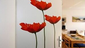 Ein Essbereich mit einem Holztisch und Stühlen, einem Bild an der Wand und einer Tür mit Schlüsselloch.