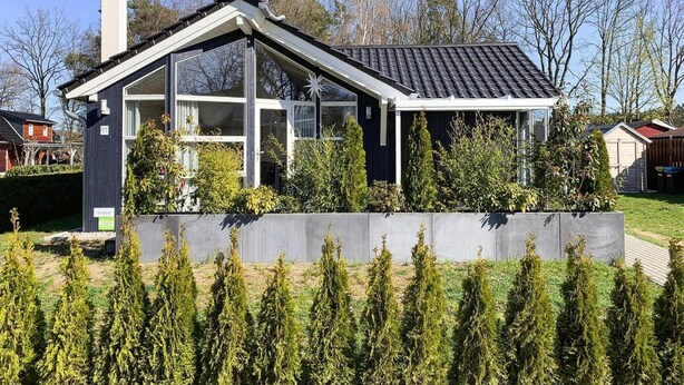 A modern house with a sloped roof, large windows, and a chimney. - Ferienhaus Seebrise mit Sauna am Dummer See (Dümmer)