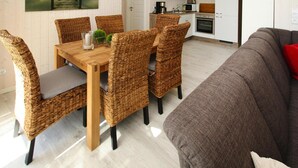 A modern kitchen with white cabinets, a microwave, and a coffee maker. - Ferienhaus Seebrise mit Sauna am Dummer See (Dümmer)