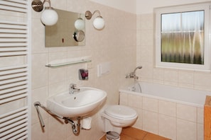 A bathroom with a sink, toilet, and bathtub. - Seepark Auenhain am Markkleeberger See in Markkleeberg (Markkleeberg)