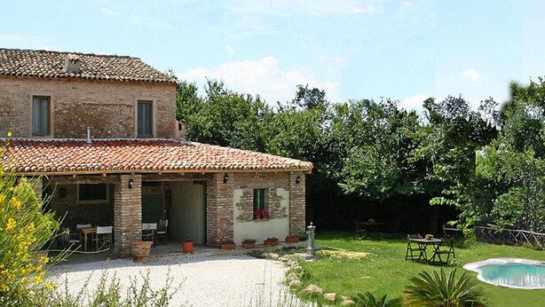 A rustic stone house with a tiled roof, a patio with outdoor furniture, and a swimming pool. - Casa by Sea in a Quiet Cove (Pesaro)