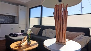 A modern living room with a sofa, coffee table, and decorative wooden sculpture.